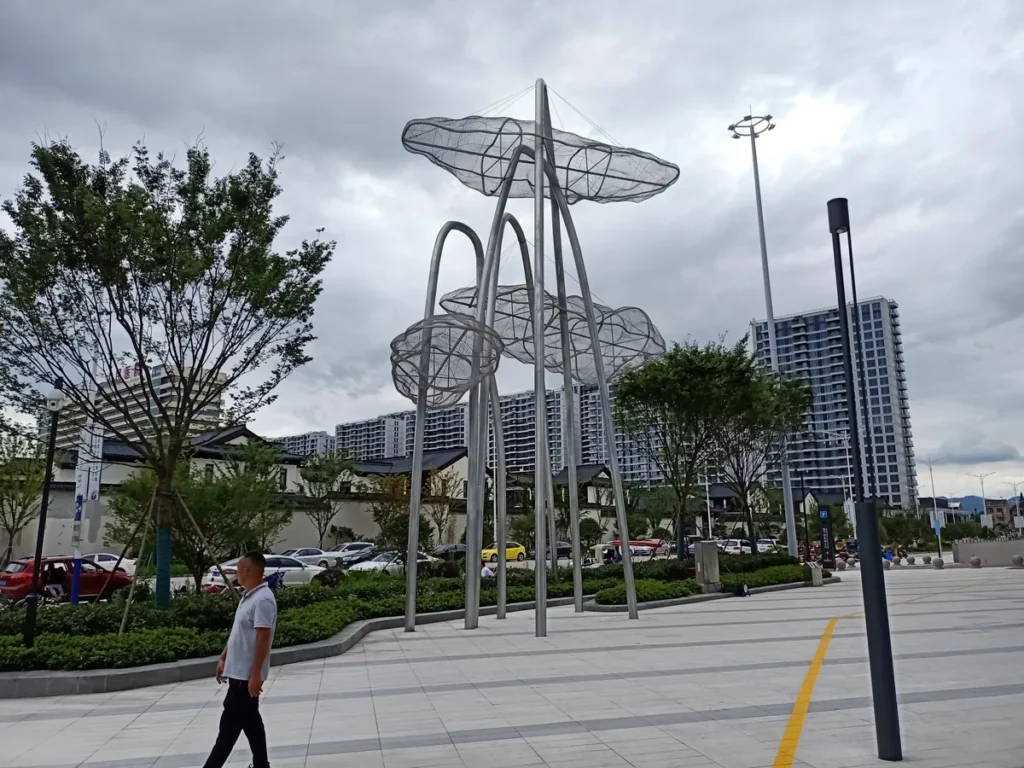 Large stainless steel mesh cloud sculpture installed in an urban landscape plaza